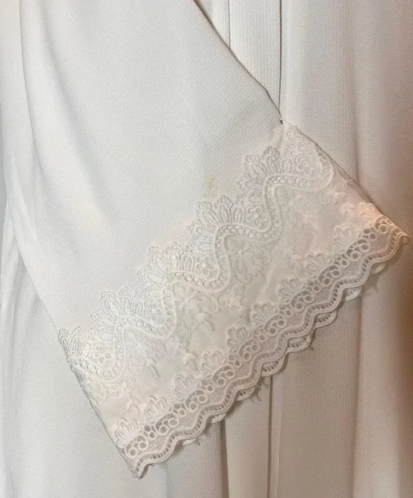 white-lilly-turkish abaya-cut-embroidery-closeup-view closeup view of white lilly turkish abaya's lace work embroidery on the sleeve end
